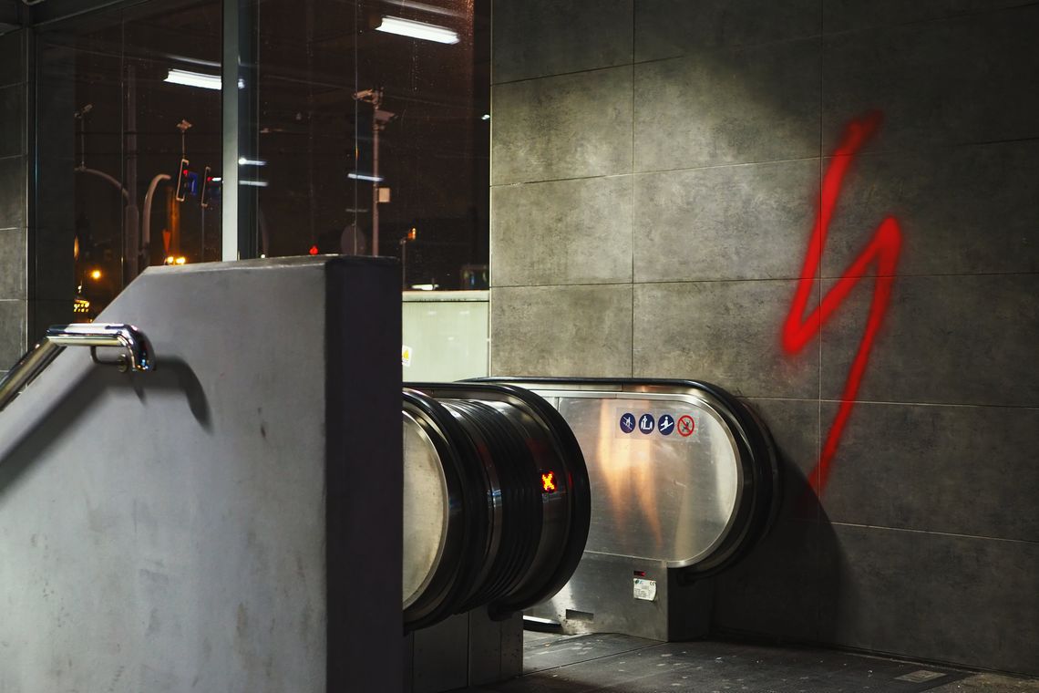 Wejście do przejścia podziemnego na Rondzie Kaponiera w Poznaniu. Na ścianie namalowana sprayem czerwona błyskawica.